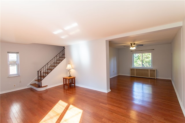 unfurnished room featuring ceiling fan, radiator, and wood-type flooring