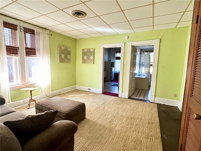 sitting room with a paneled ceiling and carpet flooring