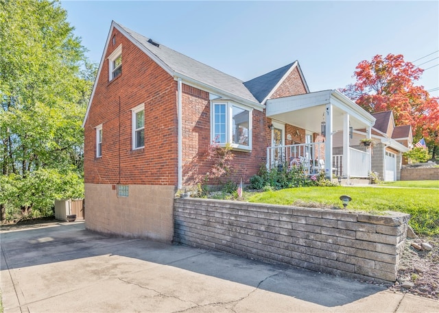 view of side of property featuring a porch and a yard