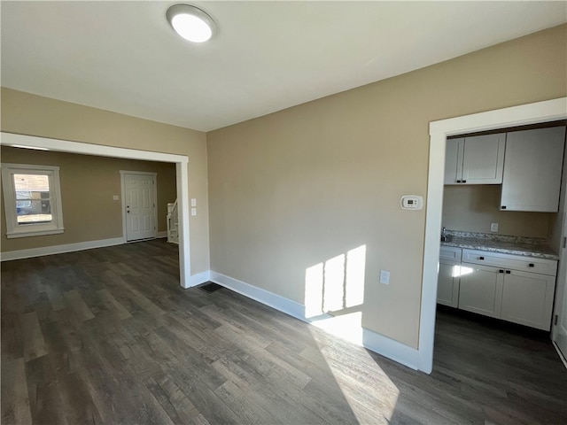 spare room with dark wood-type flooring