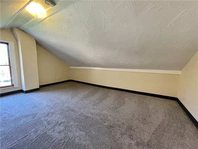 bonus room featuring carpet floors, a textured ceiling, and vaulted ceiling