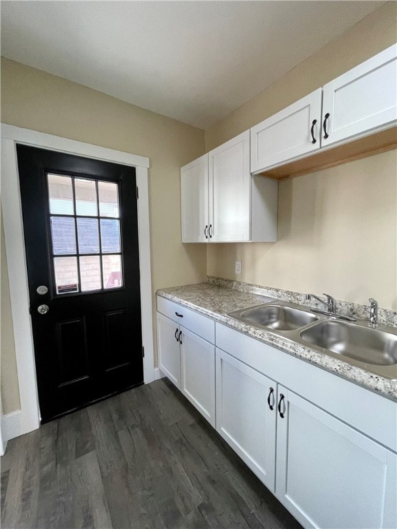 kitchen with sink, dark hardwood / wood-style flooring, and white cabinetry