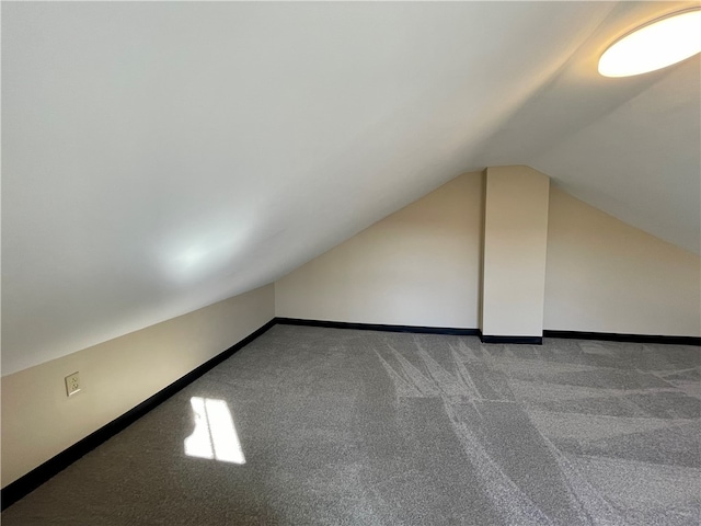 bonus room with vaulted ceiling and carpet