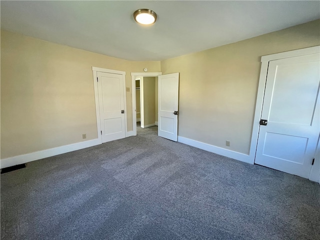 spare room with dark colored carpet