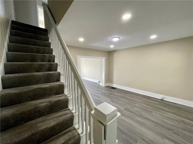 stairs featuring hardwood / wood-style floors