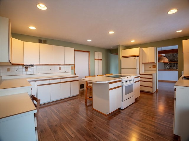 kitchen featuring white appliances, a kitchen island, visible vents, decorative backsplash, and dark wood-style floors