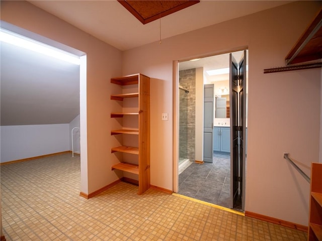 spacious closet featuring attic access and tile patterned floors