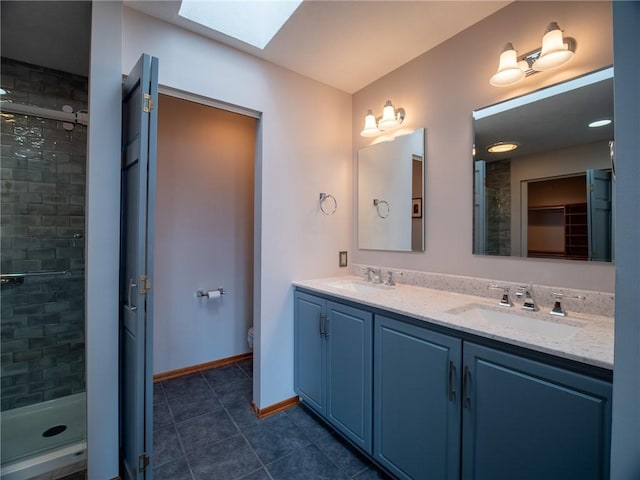 full bathroom featuring a skylight, tile patterned flooring, a sink, and a shower stall