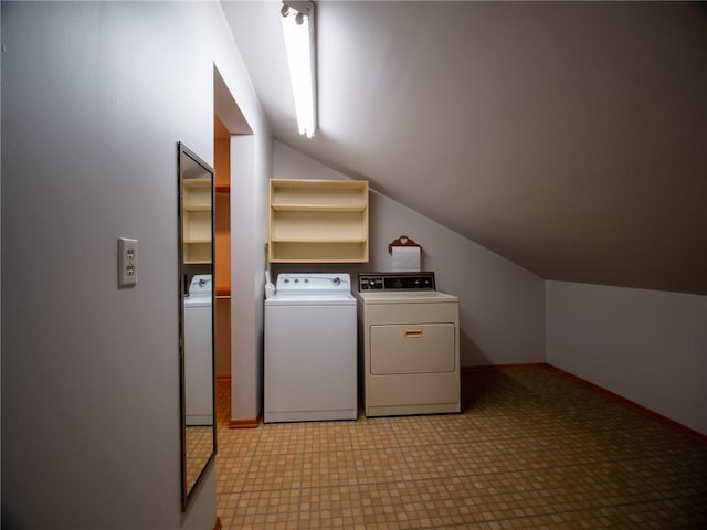 clothes washing area featuring laundry area, light floors, washing machine and dryer, and baseboards