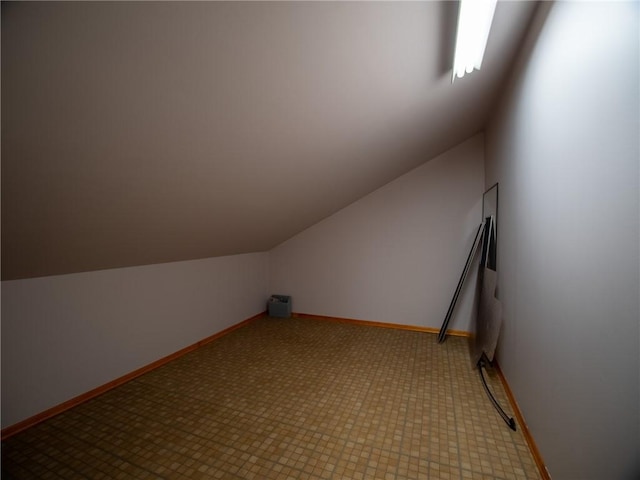 bonus room featuring lofted ceiling and baseboards