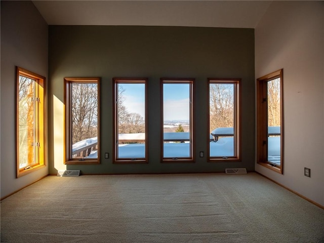 carpeted empty room featuring visible vents