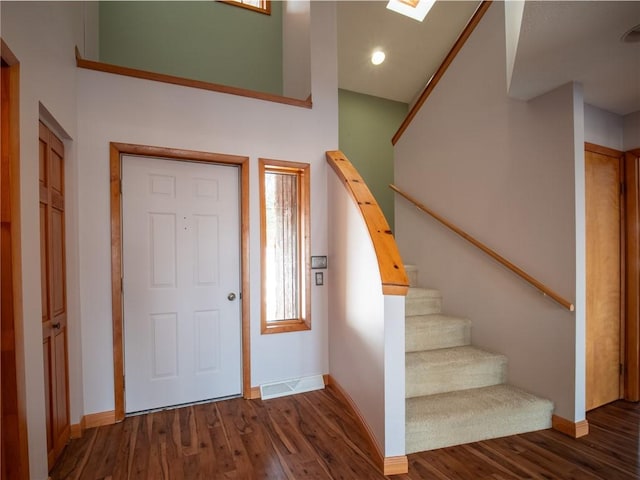 foyer with a high ceiling, stairs, baseboards, and wood finished floors