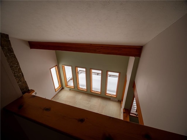 stairs with a textured ceiling and visible vents