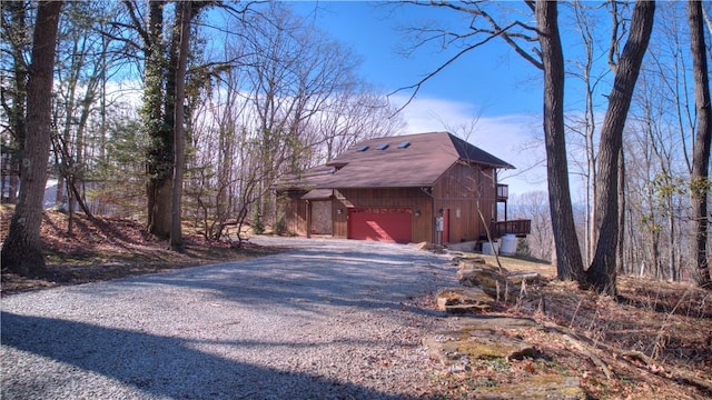 view of home's exterior with gravel driveway and a garage