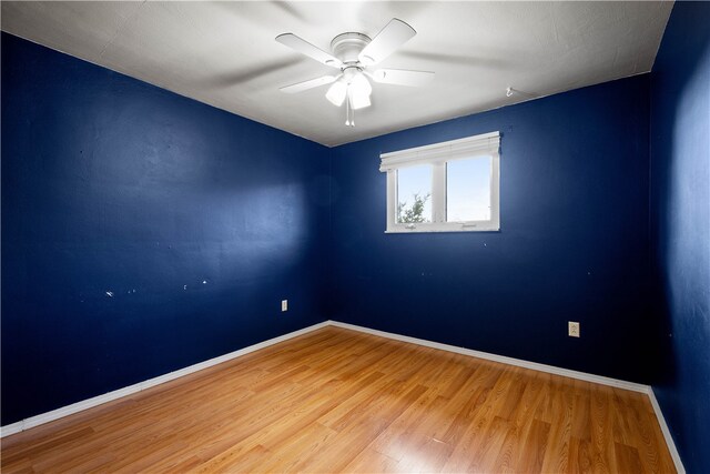 spare room with hardwood / wood-style floors and ceiling fan