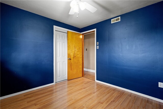 spare room with ceiling fan and light wood-type flooring