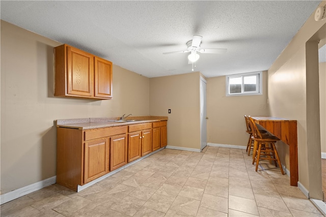 kitchen featuring ceiling fan, sink, and a textured ceiling