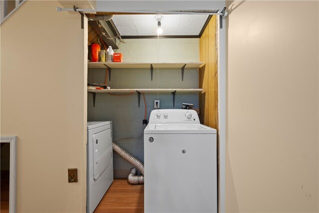 washroom with washing machine and dryer and wood-type flooring