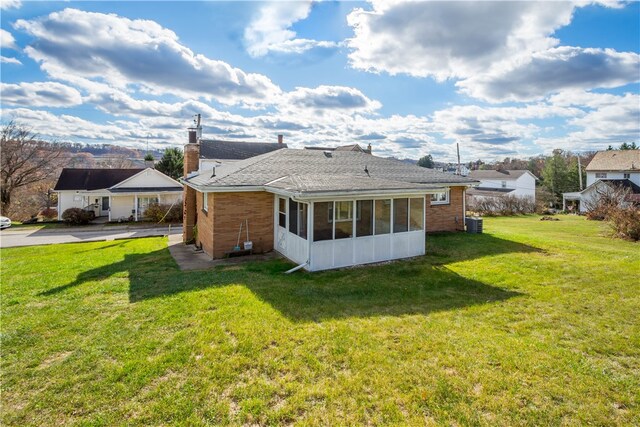 back of house with a sunroom and a yard