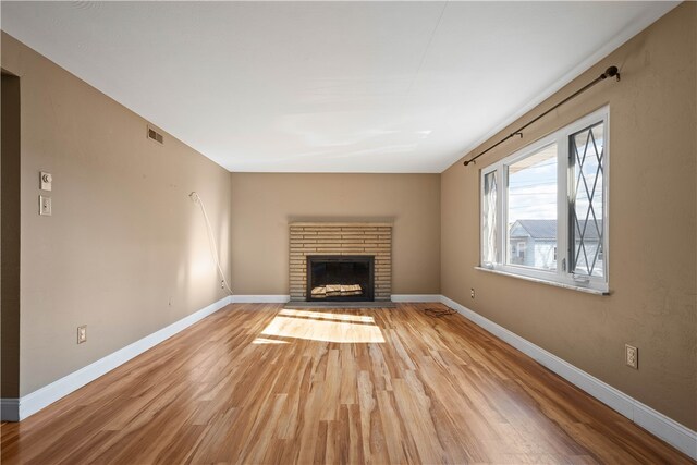 unfurnished living room with a fireplace and light hardwood / wood-style flooring