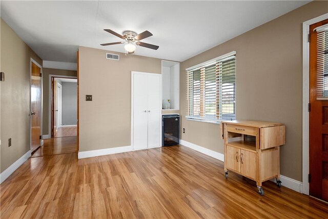 interior space with wine cooler, ceiling fan, and light hardwood / wood-style floors