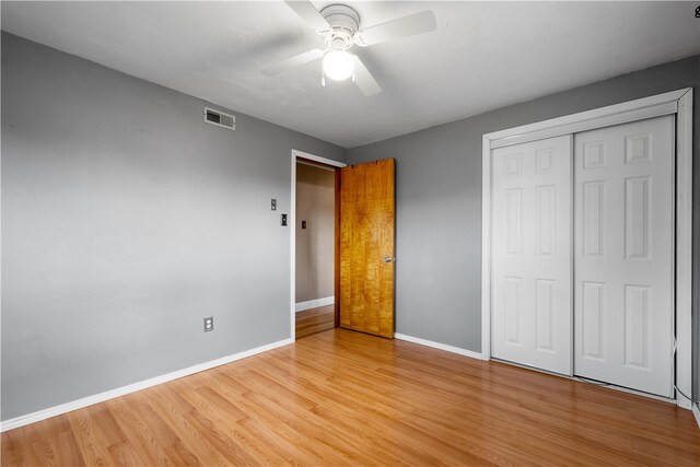 unfurnished bedroom with a closet, light hardwood / wood-style floors, and ceiling fan