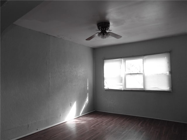 spare room featuring ceiling fan and dark wood-type flooring