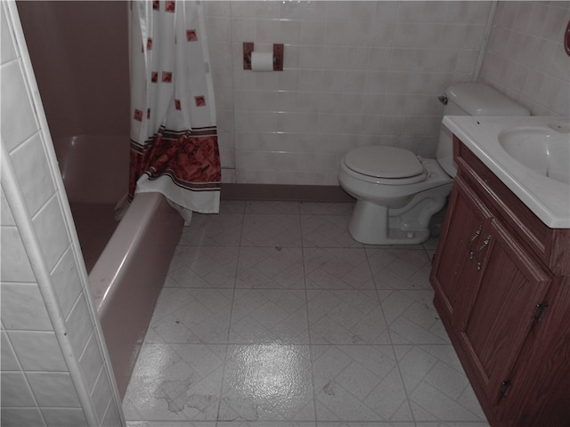 full bathroom with tile patterned flooring, toilet, tile walls, shower / tub combo with curtain, and vanity