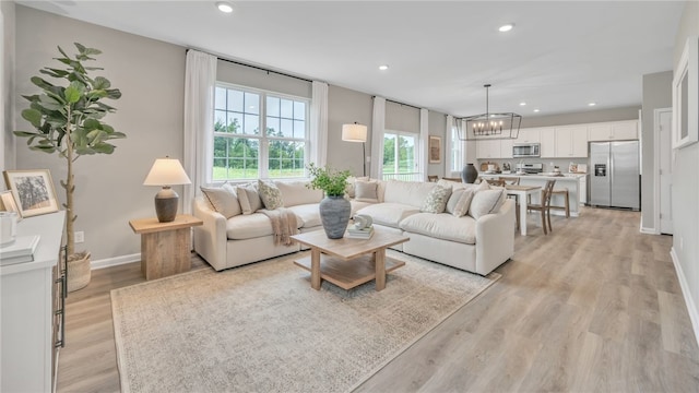 living room with a chandelier and light hardwood / wood-style floors