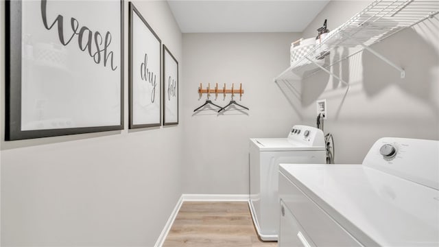 clothes washing area featuring independent washer and dryer and light hardwood / wood-style floors