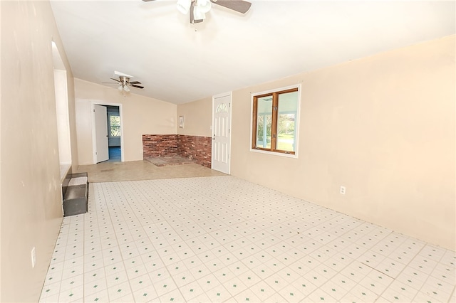 unfurnished living room featuring a wealth of natural light, lofted ceiling, and ceiling fan