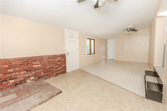 interior space featuring brick wall and ceiling fan