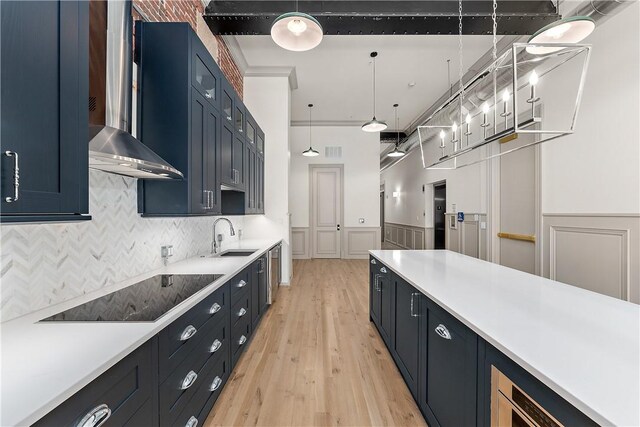 915 Liberty Ave Unit 2, Downtown Pgh, PA 15222 - kitchen with black electric cooktop, a sink, light countertops, light wood-style flooring, and decorative backsplash