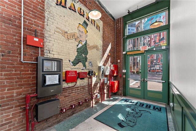 915 Liberty Ave Unit 2, Downtown Pgh, PA 15222 - interior space featuring brick wall, speckled floor, french doors, and a towering ceiling