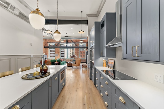 kitchen featuring pendant lighting, gray cabinetry, black electric stovetop, and light hardwood / wood-style flooring