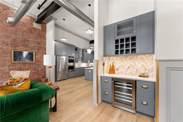 kitchen with beamed ceiling, pendant lighting, a towering ceiling, wine cooler, and stainless steel appliances