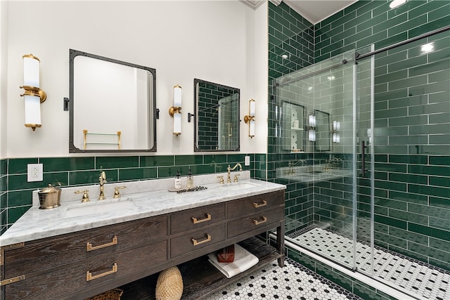 bathroom with a shower with door, tile patterned floors, vanity, and tile walls