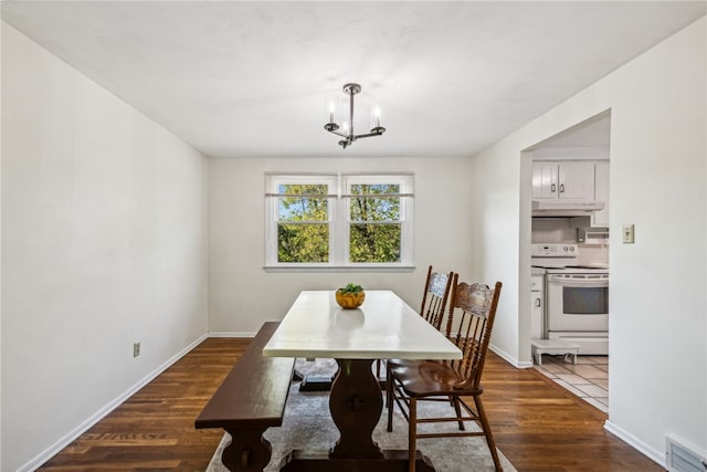 dining space with dark hardwood / wood-style floors and a notable chandelier