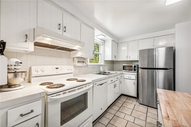 kitchen featuring white cabinets, sink, appliances with stainless steel finishes, and tasteful backsplash