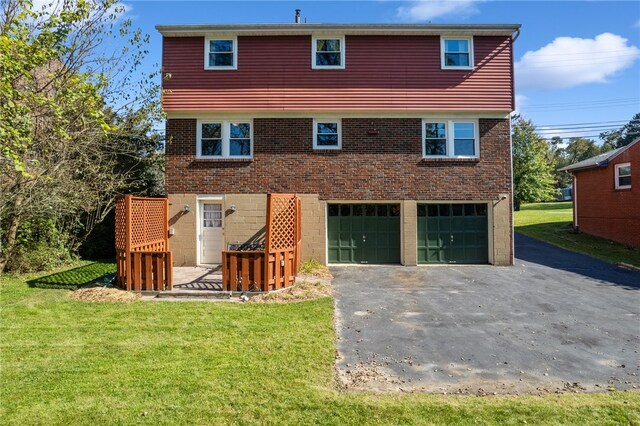 back of property with a lawn and a garage