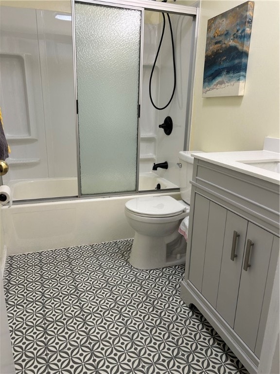 full bathroom with shower / bath combination with glass door, tile patterned floors, vanity, and toilet