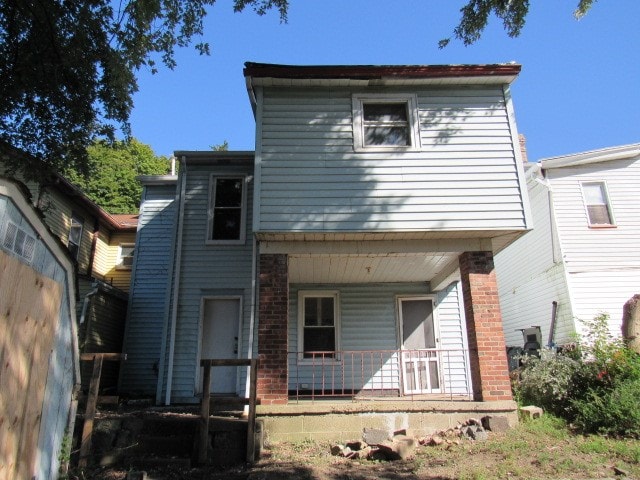 back of property with a porch