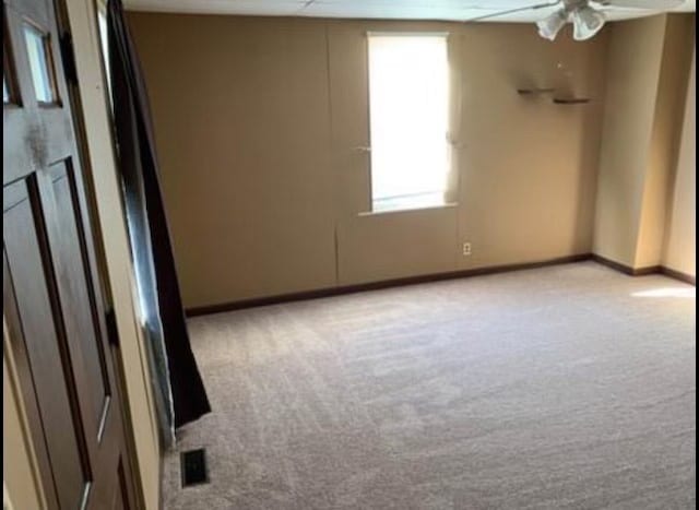 empty room with ceiling fan and light colored carpet