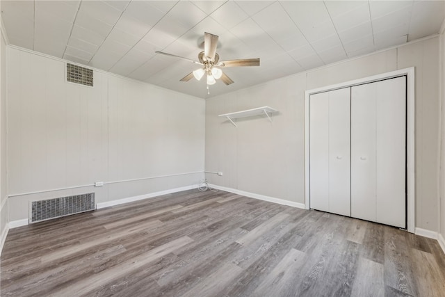 unfurnished bedroom with ornamental molding, ceiling fan, a closet, and light hardwood / wood-style floors