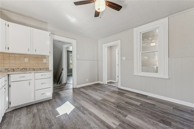 kitchen featuring ceiling fan, dark wood-type flooring, backsplash, and white cabinets