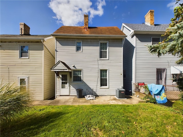 rear view of house featuring central AC unit, a yard, and a patio area