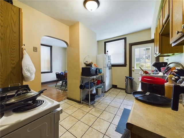 kitchen featuring white appliances and light tile patterned floors