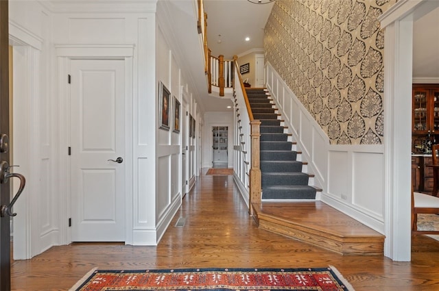 entryway featuring ornamental molding and wood-type flooring