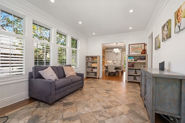 living room featuring light hardwood / wood-style floors, ornamental molding, and a chandelier