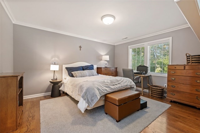 bedroom with hardwood / wood-style floors and crown molding